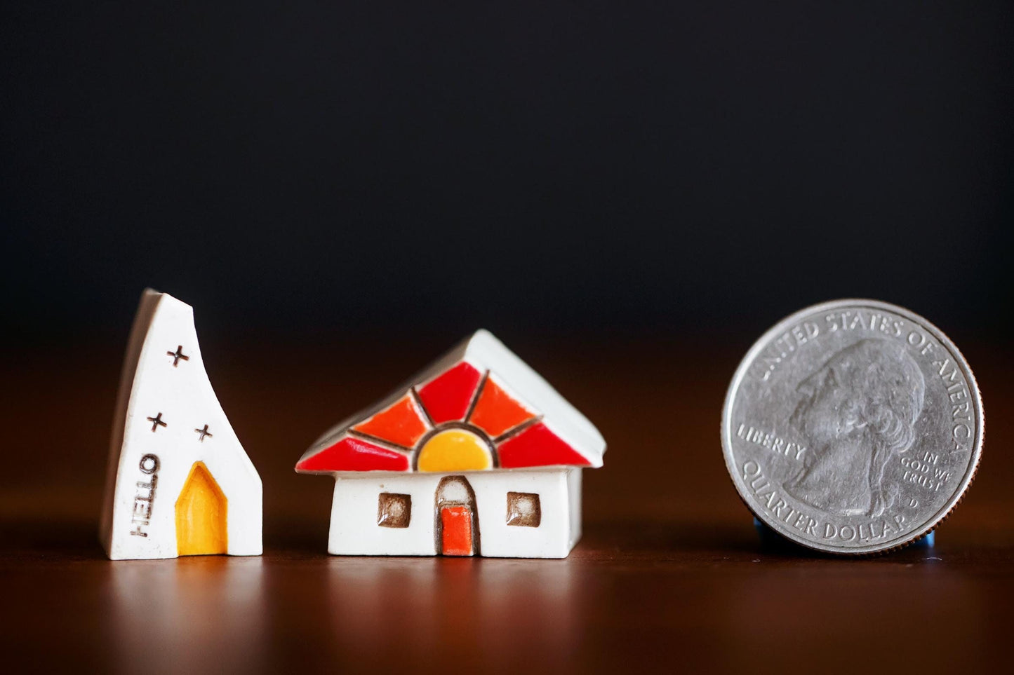 Miniature white ceramic houses with sunshine and orange door.