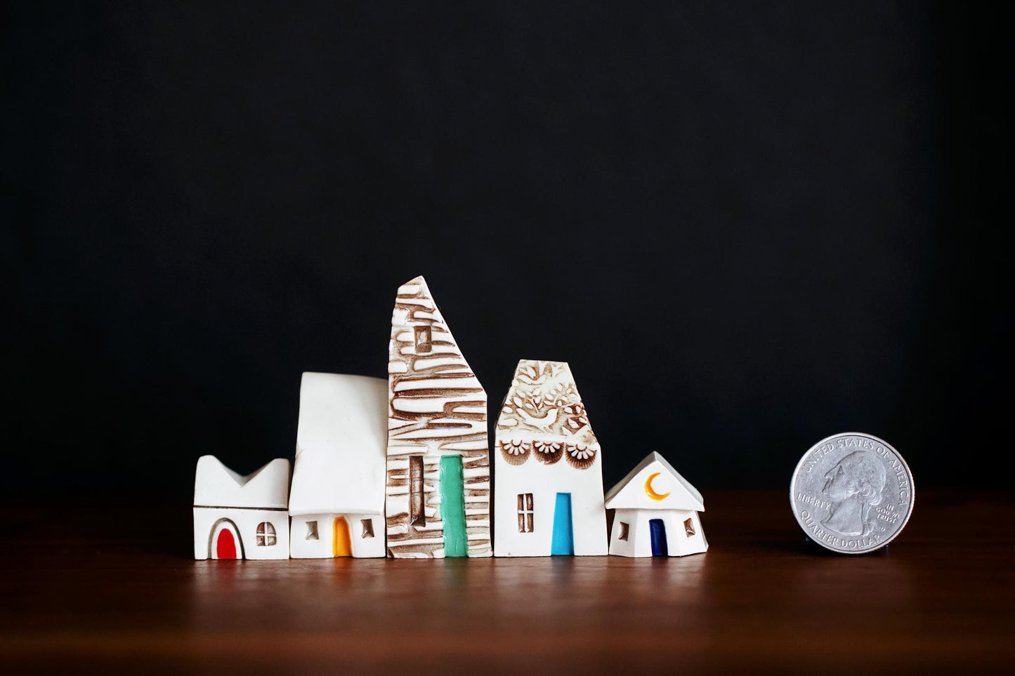 Whimsical tiny ceramic fairy houses with rainbow of doors.