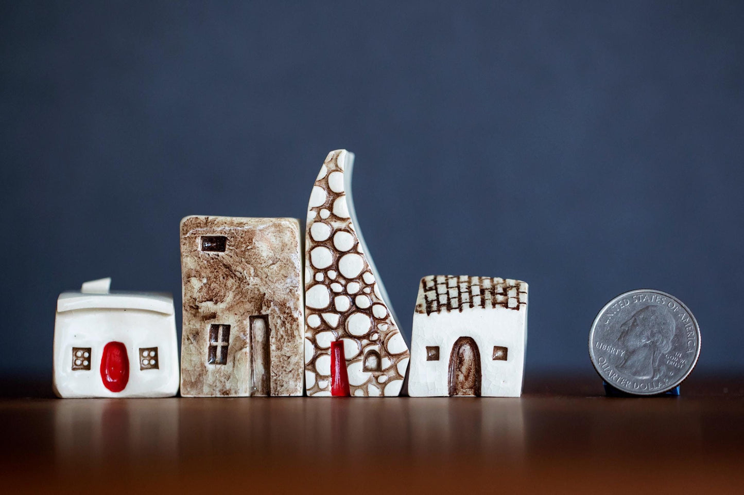 A set of four white ceramic Prague houses with different textures and red doors.