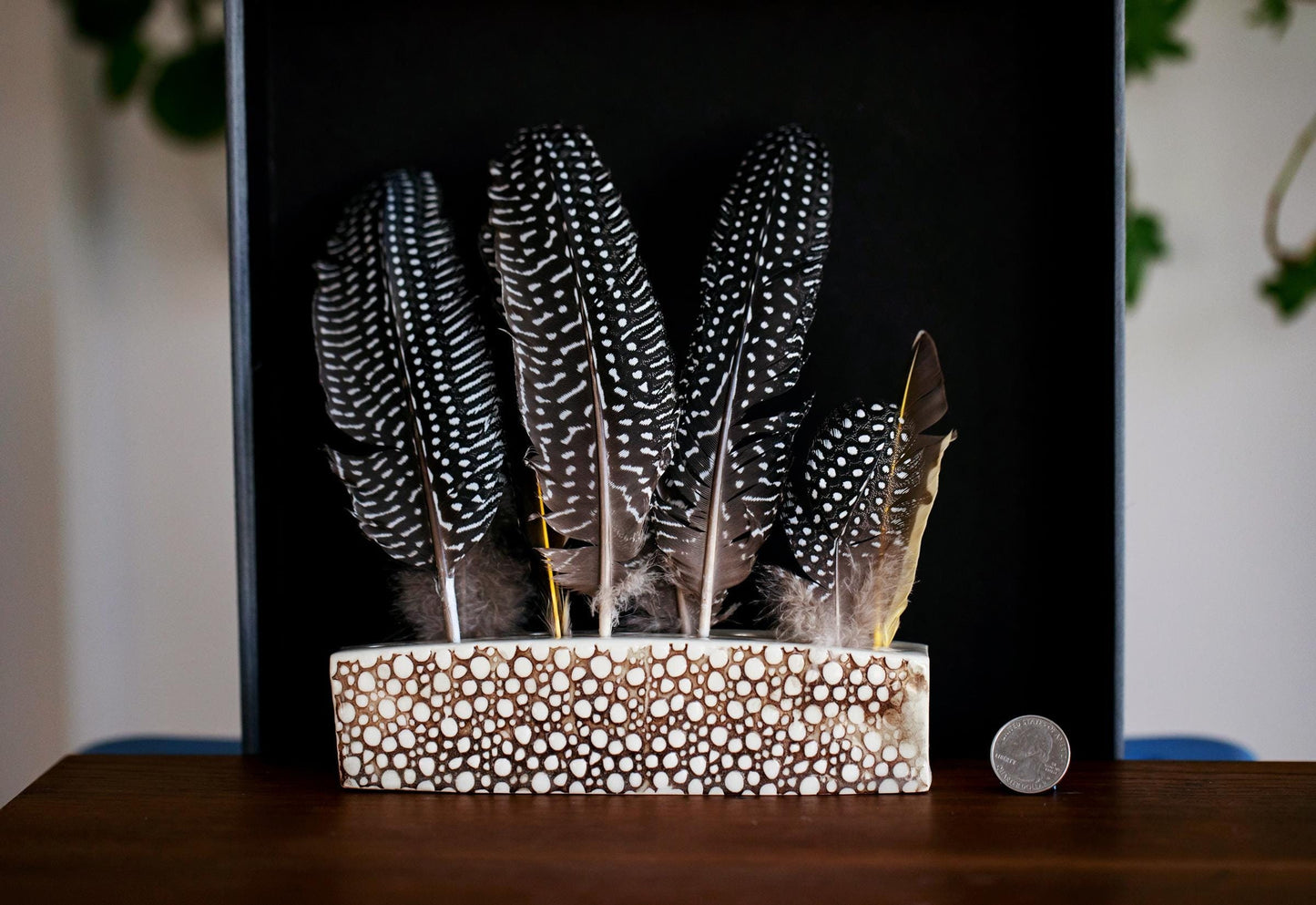 Ceramic feather holder for display on mantle.