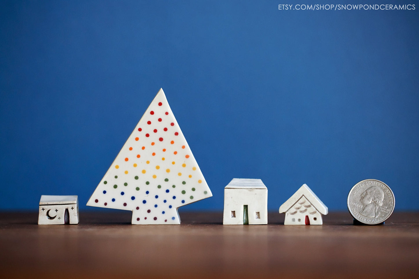 Miniature ceramic houses and tree with rainbow of lights.