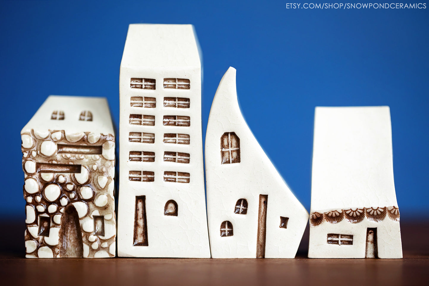 Set of four miniature white ceramic houses modeled after Prague homes.