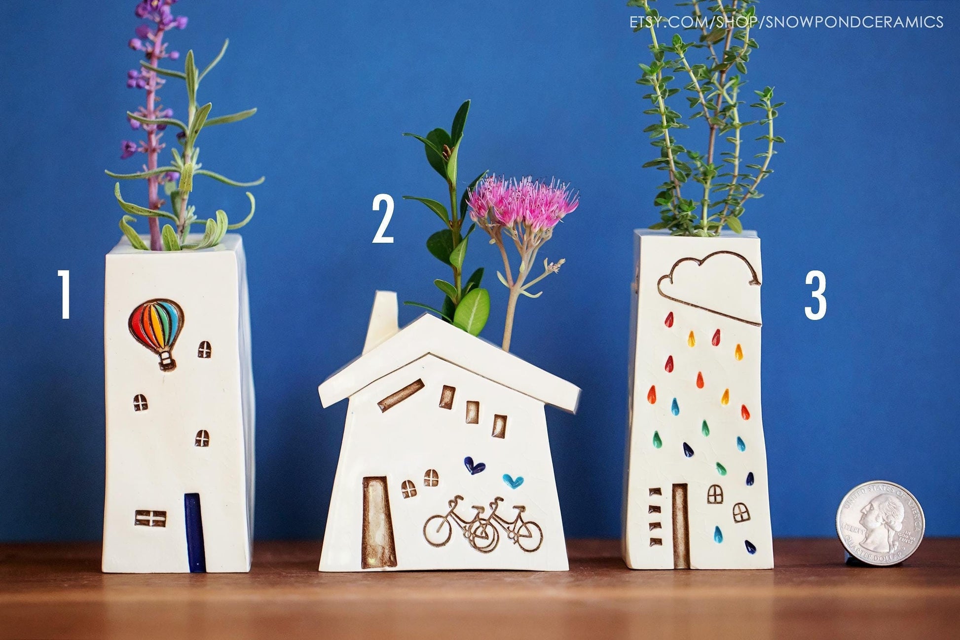 A small ceramic bud vase with two bicycles and blue hearts.