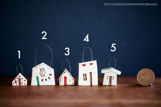 Tiny white ceramic house shaped Christmas ornaments with hearts, owls, and rainbow dots.